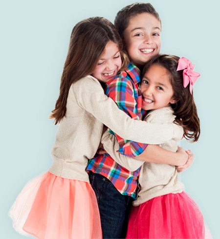 Three smiling kids hugging