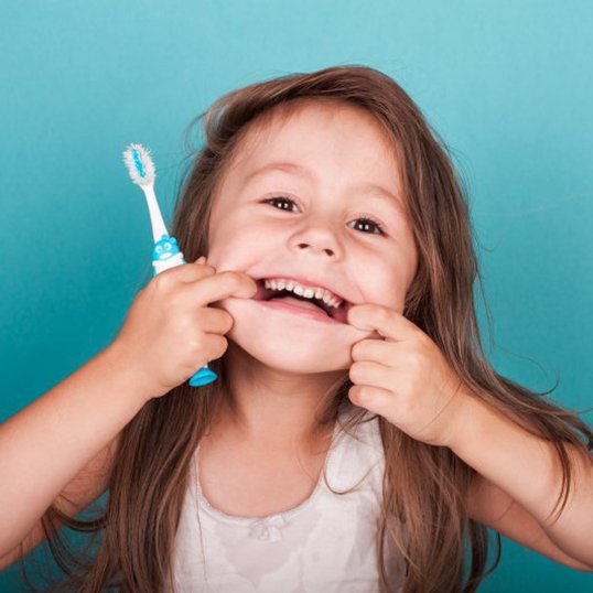 Child smiles with toothbrush