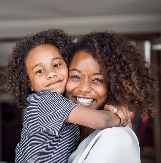 Smiling mother hugging her child
