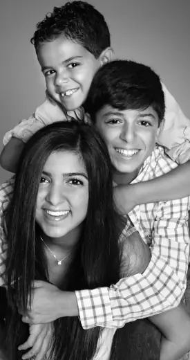 Three children smiling and hugging