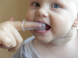 A baby's teeth and gums being cleaned 