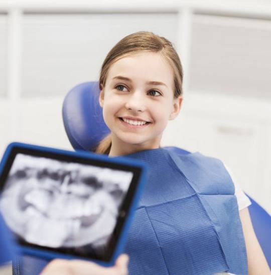 Dentist discussing X-rays with young female patient