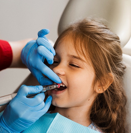 Dentist cleaning child’s teeth