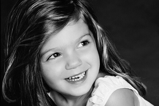 Young girl smiling and looking off to the side