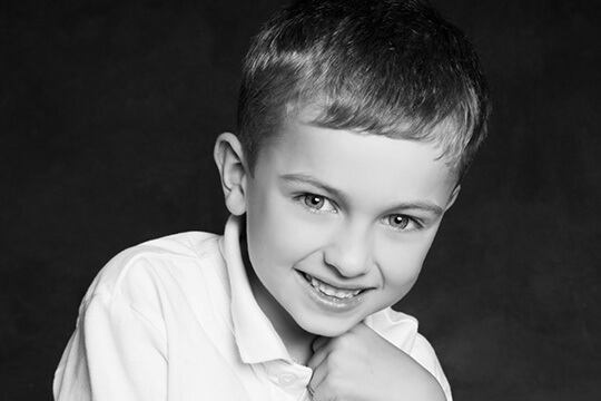 Boy smiling with his hand under his chin