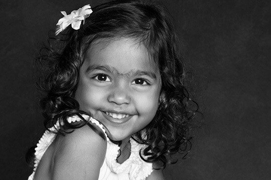 Grinning girl with curly hair and flower headband