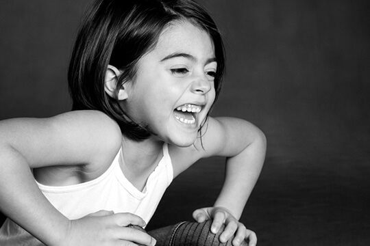 Girl sitting with her hands on her knees and pretending to scream