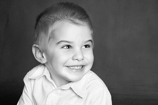 Boy in polo shirt grinning and looking to the side
