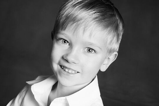 Young boy smiling in collared shirt