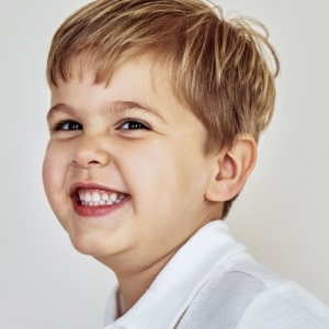 Girl with long curly hair grinning outdoors