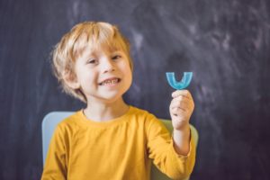 Child holding a blue mouthpiece