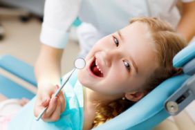 A little girl with red hair seeing a pediatric dentist