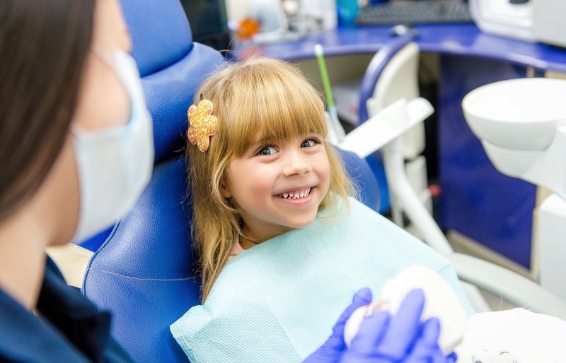 a little girl smiling at her dental hygienist during her appointment