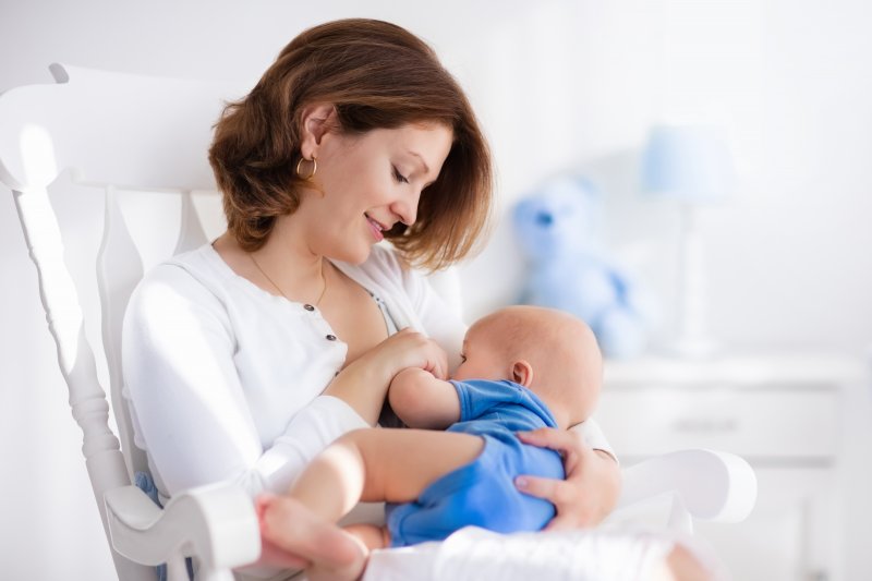 a mother nursing her baby while sitting in a rocking chair