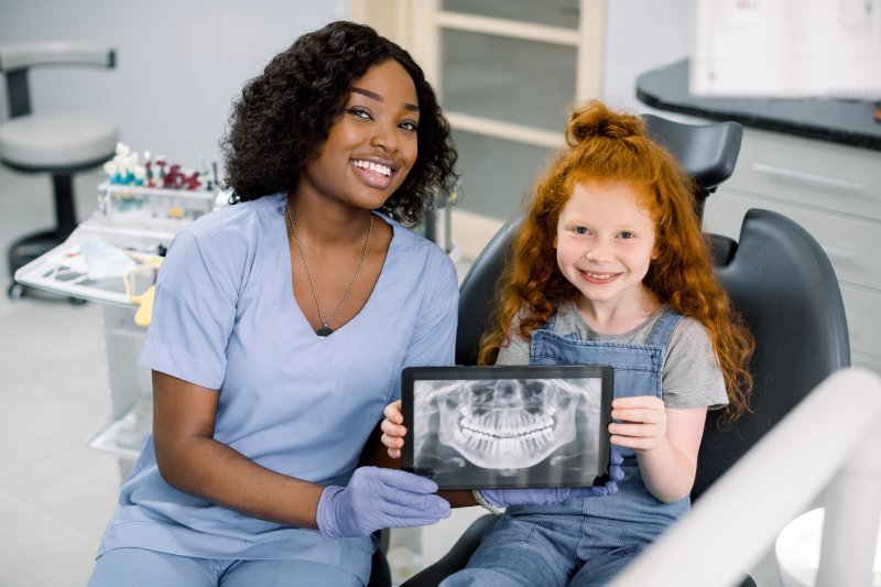 a child holding a tablet with her dental x-rays in Attleboro