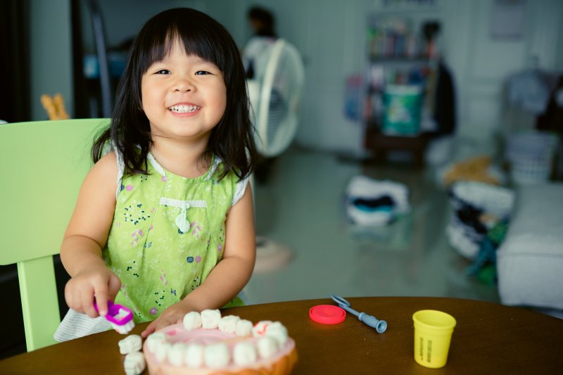 little girl pretending to brush teeth