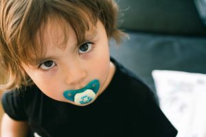 a toddler using a pacifier