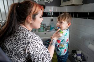 a mom brushing her child's teeth