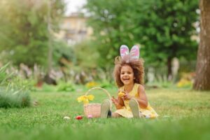 a child with bunny ears on hunting for Easter eggs