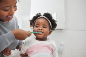 a parent brushing their child's teeth