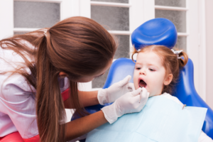 a child having their teeth examined by a pediatric dentist